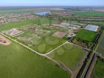 Rural landscape. View from above. On the horizon there is a poultry farm, a field, forest belts and a river.