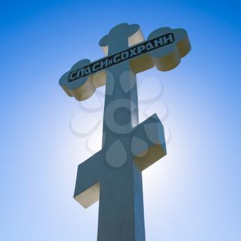 Krasnodar, Russia - April 29, 2017: Orthodox cross against the blue sky and the sun. Cross in the backlight of the sun. Symbol of the Christian faith. The inscription on the cross: salvation and preservation