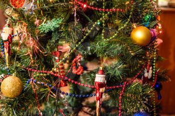 Tinsel and toys, balls and other decorations on the Christmas Christmas tree standing in the open air. Decorations New Year tree.