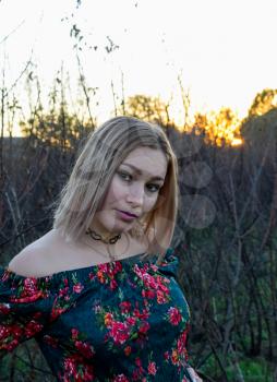 The lady on the background of dry trees. Woman in a dress