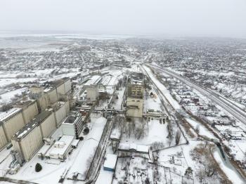 Sprinkled with snow grain elevator. Winter view of the old Soviet elevator. Winter view from the bird's eye view of the village. The streets are covered with snow.