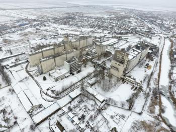 Sprinkled with snow grain elevator. Winter view of the old Soviet elevator. Winter view from the bird's eye view of the village. The streets are covered with snow.