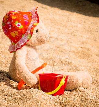Teddy Bear With Hat Sitting On The Sand