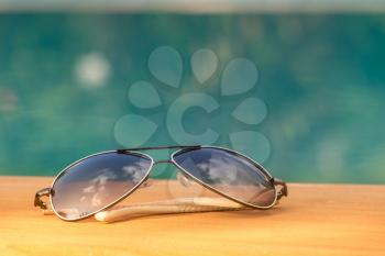 Sunglasses Near A Swimming Pool Showing Vacation