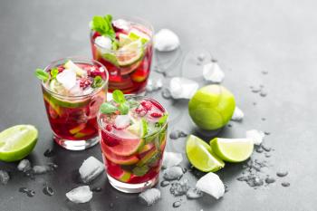 Raspberry mojito cocktail with lime, mint and ice, cold refreshing drink