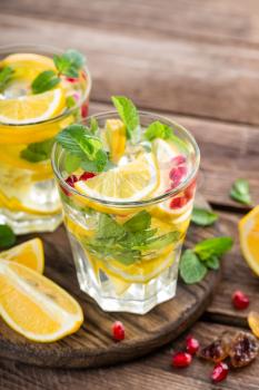 Lemon mojito cocktail with mint and pomegranate, cold refreshing drink or beverage