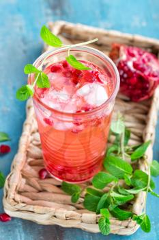 Infused pomegranate water with fresh lemon and ice, cold healthy refreshing and detox drink