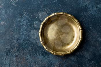Empty metal plate on dark texture background top view, copy space