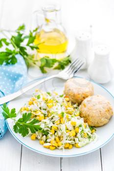 Vegetable cabbage salad and meatballs on plate close up, white background