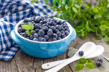 Fresh blueberries with leaves on wooden background