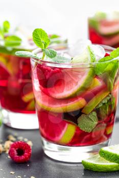 Raspberry mojito cocktail with lime, mint and ice, cold, iced refreshing drink or beverage