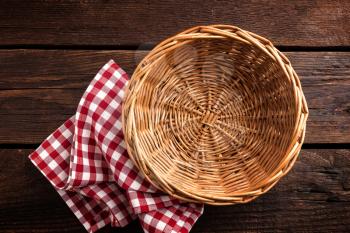 Empty wicker basket on a wooden background, top view