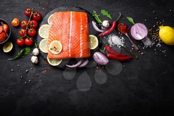 Fresh raw salmon red fish fillet on black background. Top view