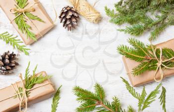 Decoration of the tree branches, cones, gifts on wooden background