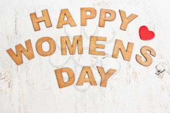 Happy Womens Day with wooden letters on an old white wooden background