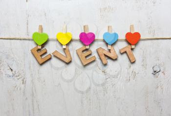 Word event of wooden letters on a white background with wooden clothespins