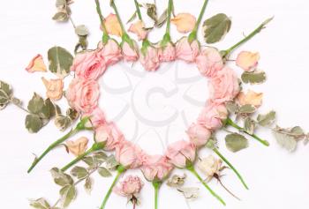 Heart of flowers, red roses and green leaves.Type flat, top view