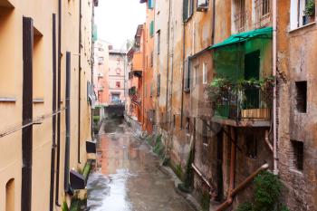  Old water canal hidden behind a window in Bologna  , Italy 