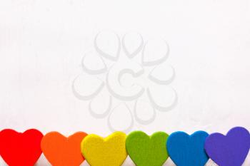 Wooden hearts of the color of the rainbow. Background of LGBT 