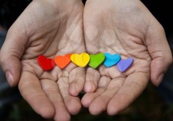 Background of LGBT .hearts of the color of the rainbow in women's hand