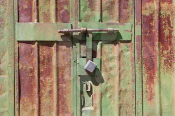 Iron, old, green gate in rust with a lock