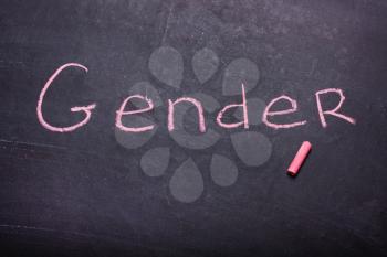 The word gender is written chalk on the blackboard
