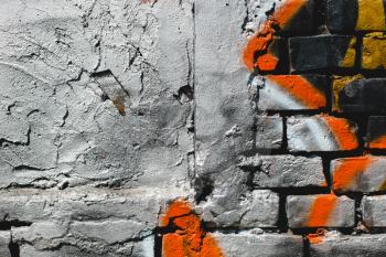 Grunge, gray dark, rough background with orange paint. Brick wall on the street.Copy space