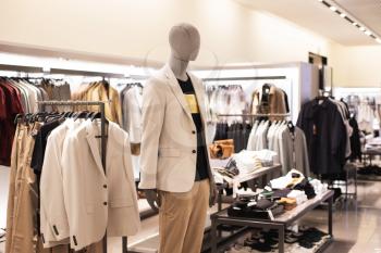 Men's clothing, fashionable, stylish on hangers in stores, a mannequin. A concept of shopping, Sales. Jacket beige, pastel colors