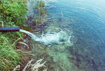 Sewage flows into the lake, river. Water flows from the pipes. Environmental pollution.