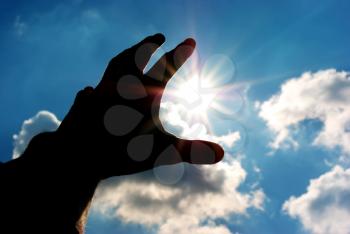 Silhouette of human hand reach to sun. Conceptual design.