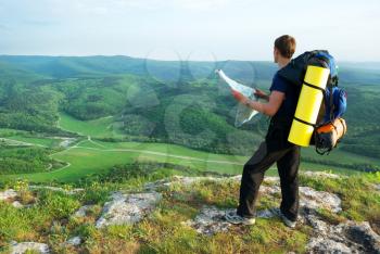 Man tourist in mountain read the map. 