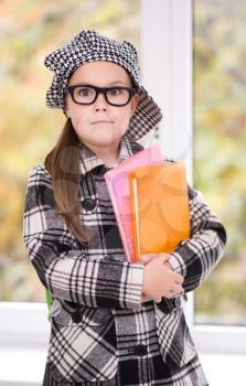 Portrait of a cute little schoolgirl with books