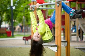 Cute happy girl is playing on playground, outdoor