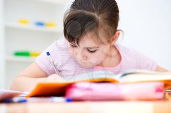 Cute girl writes a pen - concept school education