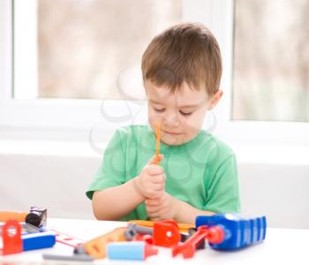 Cute little boy is playing with tools