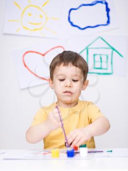 Portrait of a cute boy showing her hands painted in bright colors