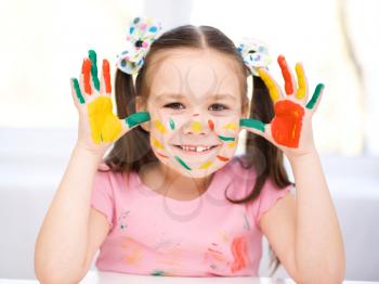 Portrait of a cute cheerful girl showing her hands painted in bright colors