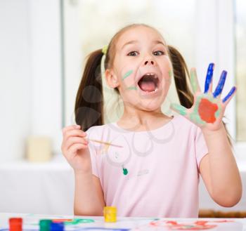 Portrait of a cute cheerful girl showing her hands painted in bright colors