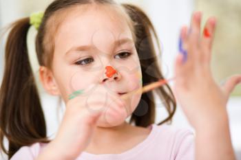 Portrait of a cute cheerful girl showing her hands painted in bright colors