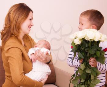 Mother holds cute baby, gift flowers for my mom