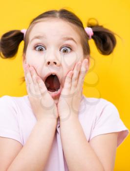 Little girl is holding her face while listening to somebody