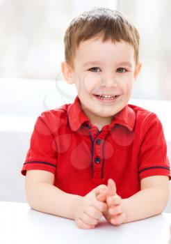 Portrait of a cute little boy supporting his head with hands
