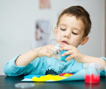 Happy boy playing with color play dough