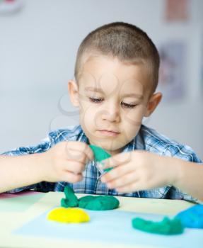 Happy boy playing with color play dough