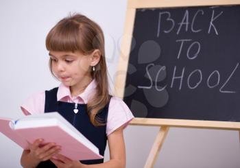 Cute girl is holding book - school concept