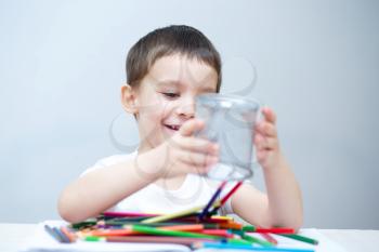 Little boy is holding bunch of color pencils