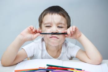 Little boy is holding bunch of color pencils