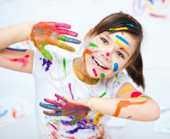 Cute girl showing her hands painted in bright colors