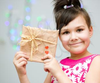 Happiness, health and love concept - smiling girl holding present