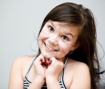 Cute girl is holding her face in astonishment and looking up
